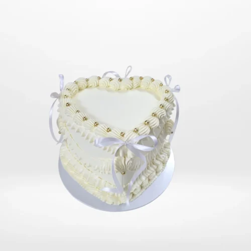 Heart Cake White – A romantic heart-shaped cake adorned with pink frosting and non-edible bows, perfect for celebrations in Birmingham.