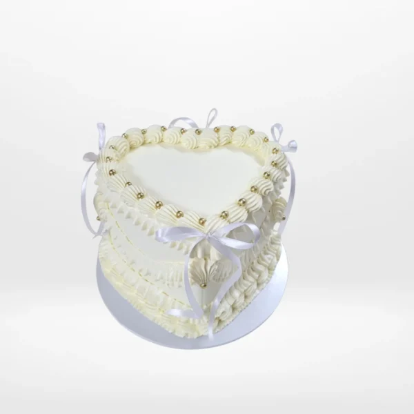 Heart Cake White – A romantic heart-shaped cake adorned with pink frosting and non-edible bows, perfect for celebrations in Birmingham.