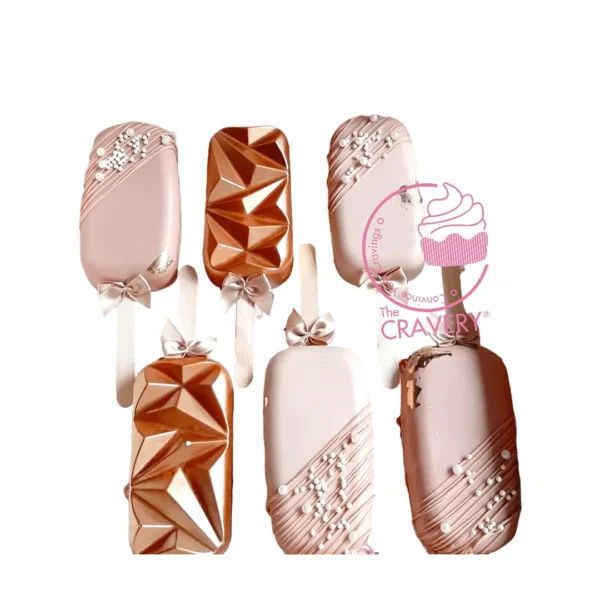 Blush coloured mini cakesicles decorated in soft romantic tones.