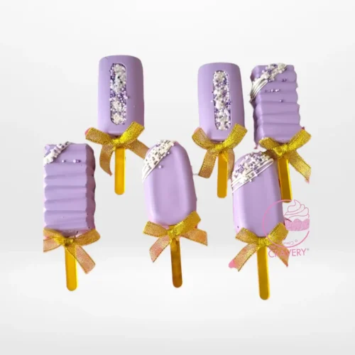 Handcrafted cakesicles decorated with chocolate and elegant designs.