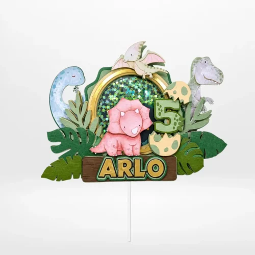Dinosaurs cake topper with layered 3D shaker design, dinosaur characters, eggs, and jungle leaves from Cake Shop Dudley.