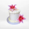 Elegant white Lilly Cake with artificial pink lily flowers from Cake Shop Birmingham.