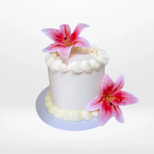 Elegant white Lilly Cake with artificial pink lily flowers from Cake Shop Birmingham.